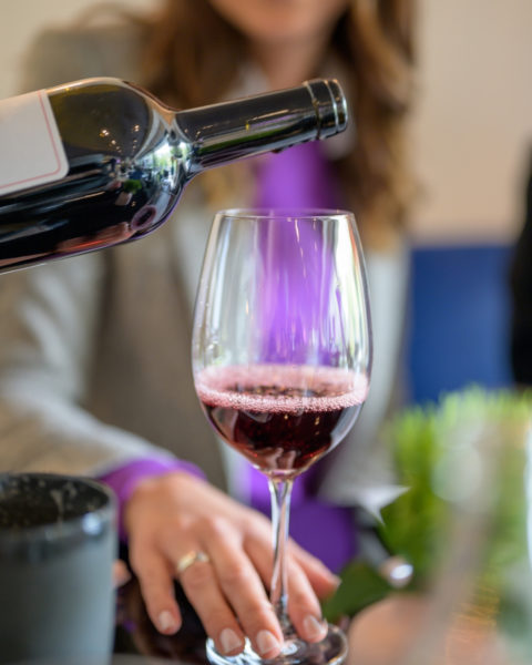 Bella Italia: Frau bekommt ein Glas Rotwein eingeschenkt